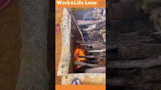 A woman ignites a woodfilled pit for charcoal covering it to trap heat for slow pyrolysis [upl. by Derfla100]