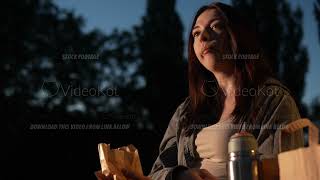 Tranquil scene of Caucasian woman enjoying warm summer evening in the park with tea and fries [upl. by Ernestine]