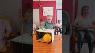 Players push long pins through a cardboard box attempting to pop the balloon [upl. by Asilenna]