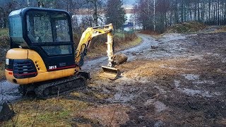 Backfilling and finishing a trench with a Cat 3015 [upl. by Ardnasak]